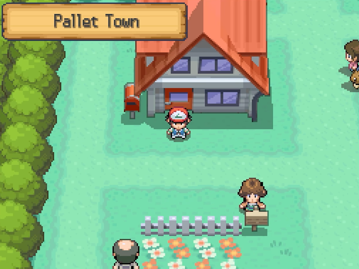 A red-clad trainer stands on a path between buildings and trees in Pallet Town.